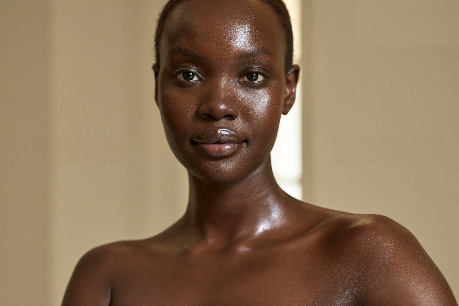 A woman with rich Fitzpatrick V to VI skin showing healthy, even, hydrated glass-skin radiance, the kind of skin quality microneedling aims to support, at Melatone Skin Clinic Battersea